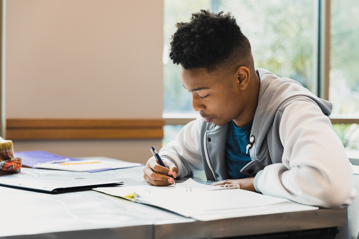 Teen boy studies by himself