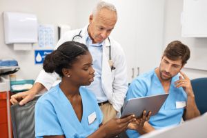 Doctor and nurses discussing over digital tablet