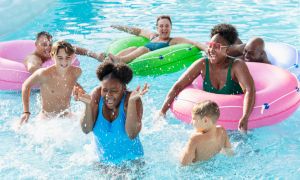 Multiracial friends and family splashing on lazy river