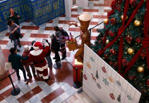 Santa Claus poses for a group picture while greeting holiday shoppers at the Stonestown Galleria shopping mall San Francisco, Calif. on Wednesday, Nov. 21, 2018. Daniel Halkyard has been portraying Santa for 45 years but this is first time at Stonestown