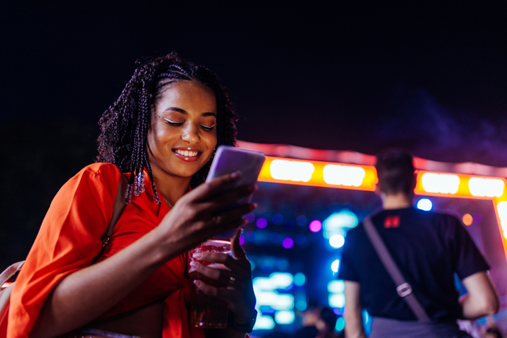 Woman using her smartphone at an outdoor music festival