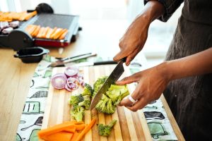Woman prepares broccoli for grilling