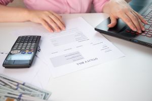 Utility bill, Invoice for energy consumption, electricity and gas receipt, a woman behind a worker considers the budget for utilities,