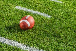 A college or high school football sitting between the hash marks