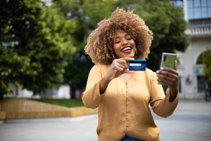 Happy woman shopping online and enjoying in the city