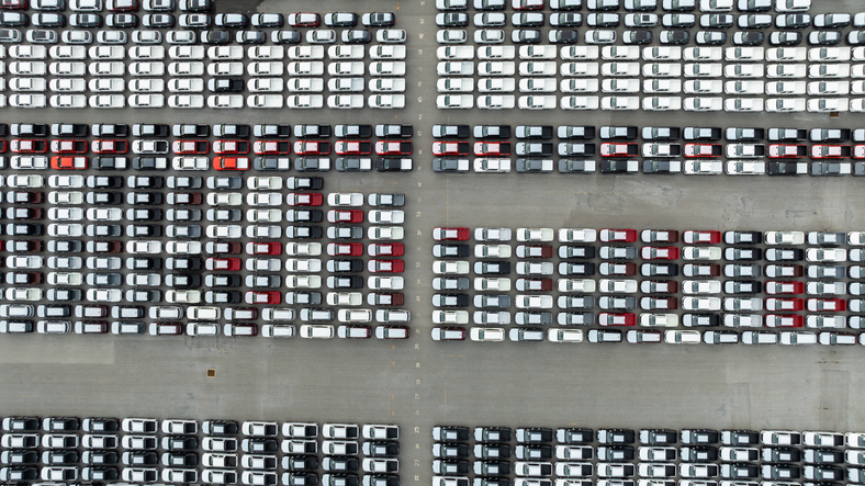 aerial top down view of a parking lot new cars lined up in the port for import and export international.