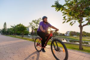 Woman Riding a Bicycle in a Public Park at Sunset