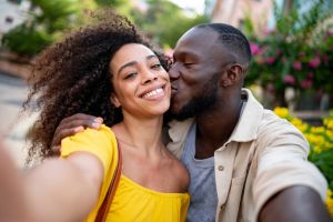 Loving couple taking a selfie while giving a kiss