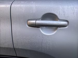 A car door handle is covered in rust