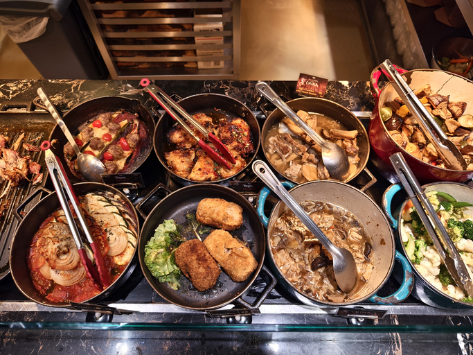 A large and diverse buffet that includes a wide variety of different types of delicious food.