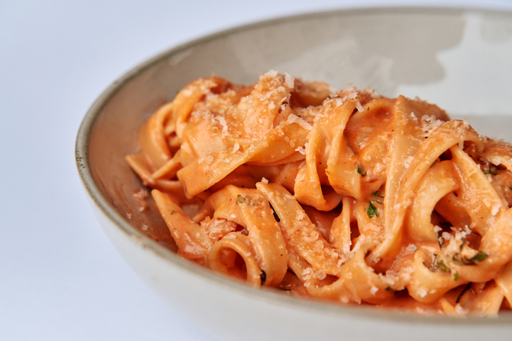 Delicious Fettuccine Pasta with Rich Tomato Cream Sauce and Cheese Garnish Served in a Stylish Bowl, Perfect for Any Italian Cuisine Lover's Delight